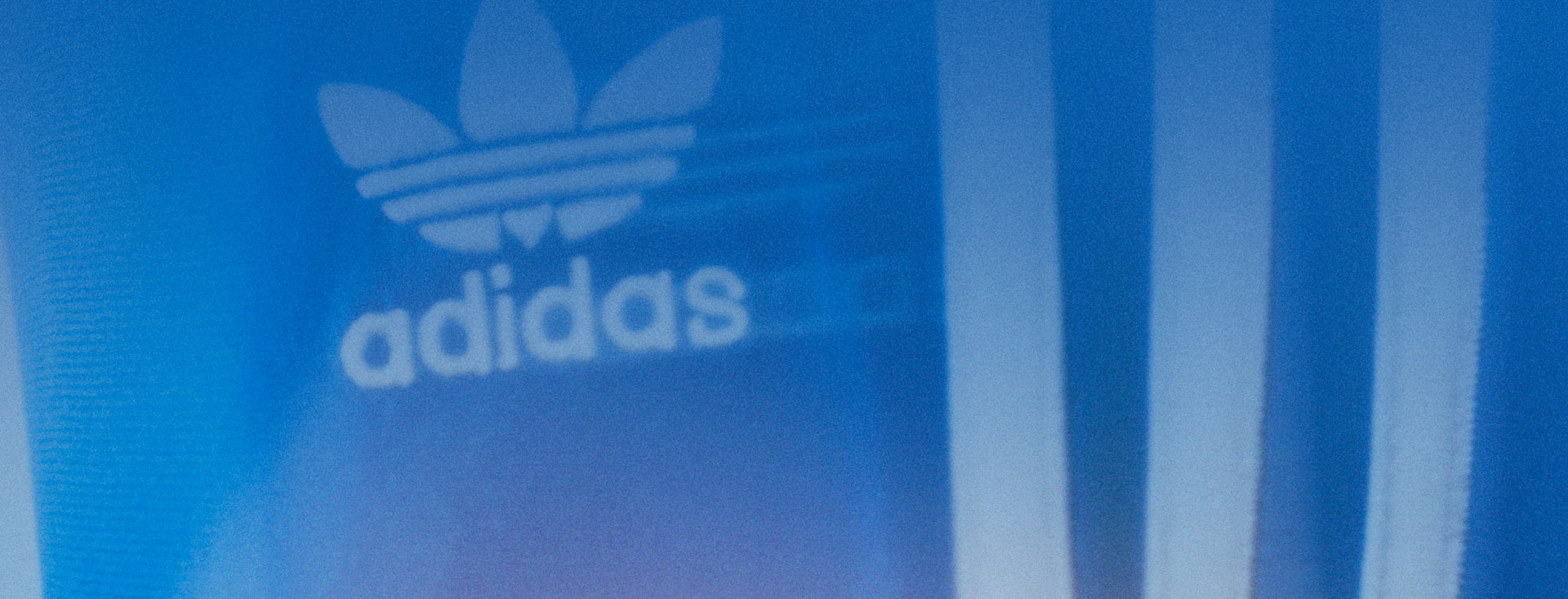 Eine blaue adidas Jacke mit originals Logo und drei Streifen (Foto)