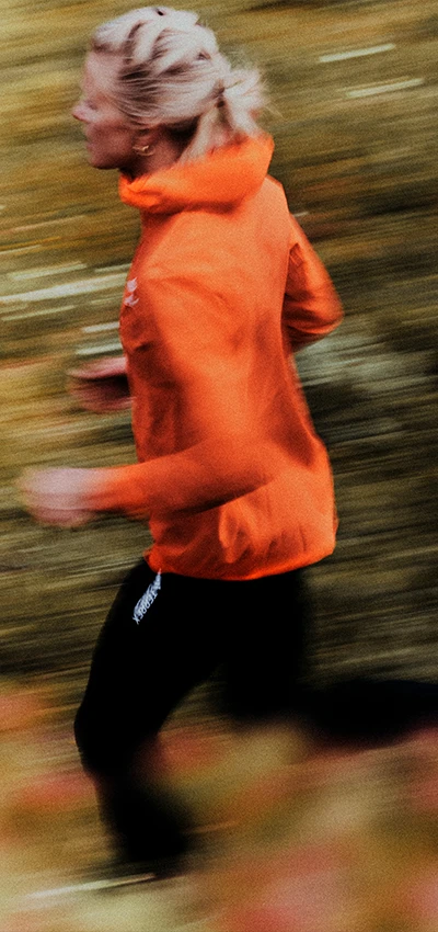 This image shows a person running in the foreground, captured with motion blur, which suggests that the runner is in motion. 
