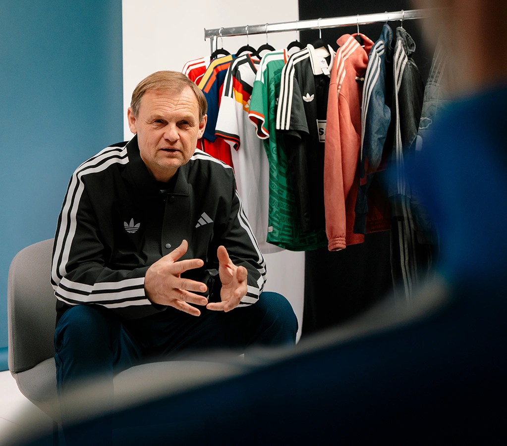 adidas CEO Bjørn Gulden im Gespräch vor adidas Bekleidung auf Kleiderständer. (Foto)