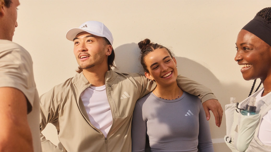 Group of young adults talking while wearing adidas sportswear. (Photo)