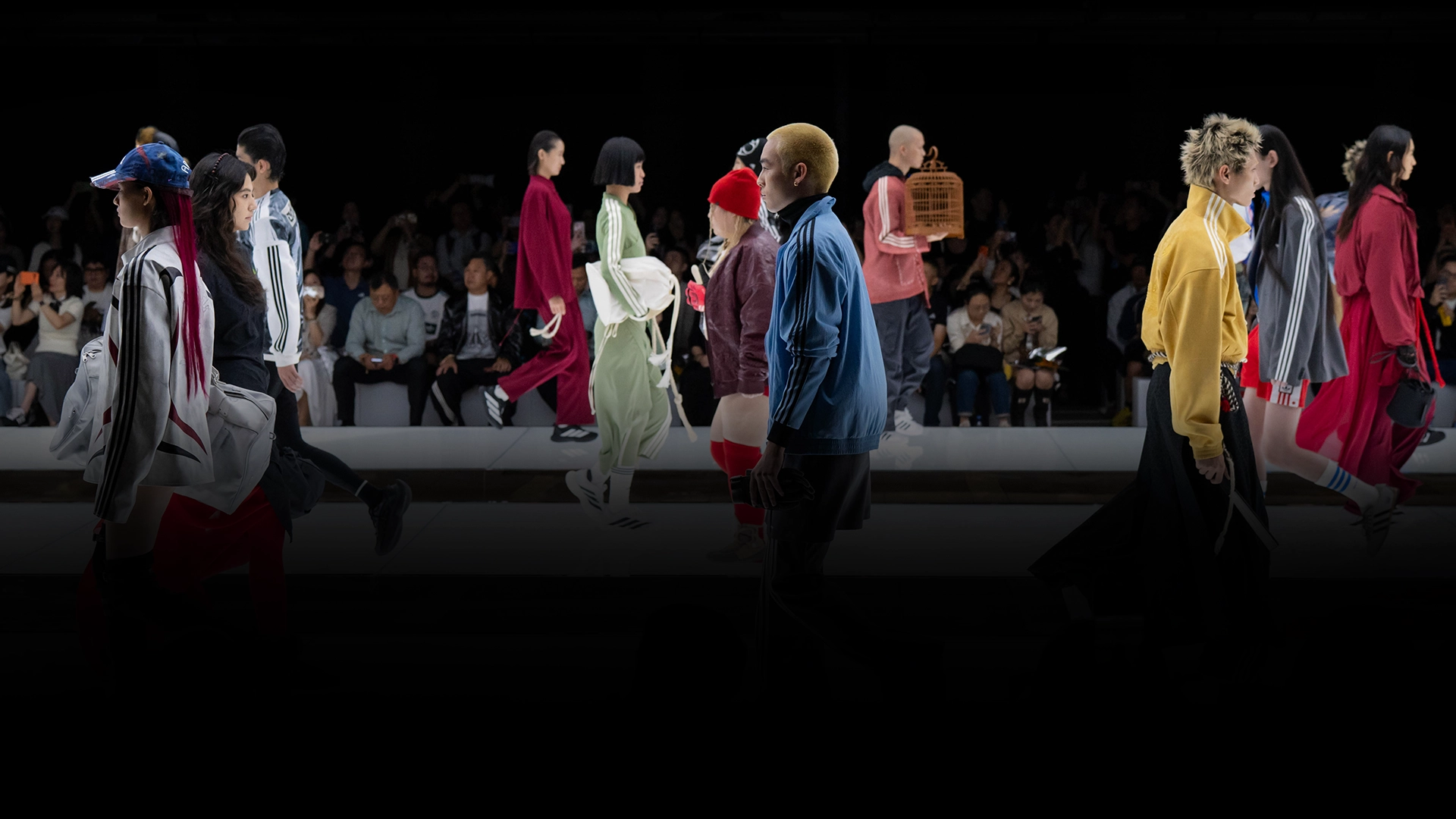 Models presenting adidas outfits on a runway in front of an audience. (Photo)