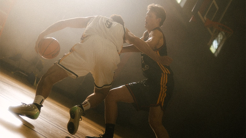 Two men playing basketball indoors, contesting the ball. (Photo)
